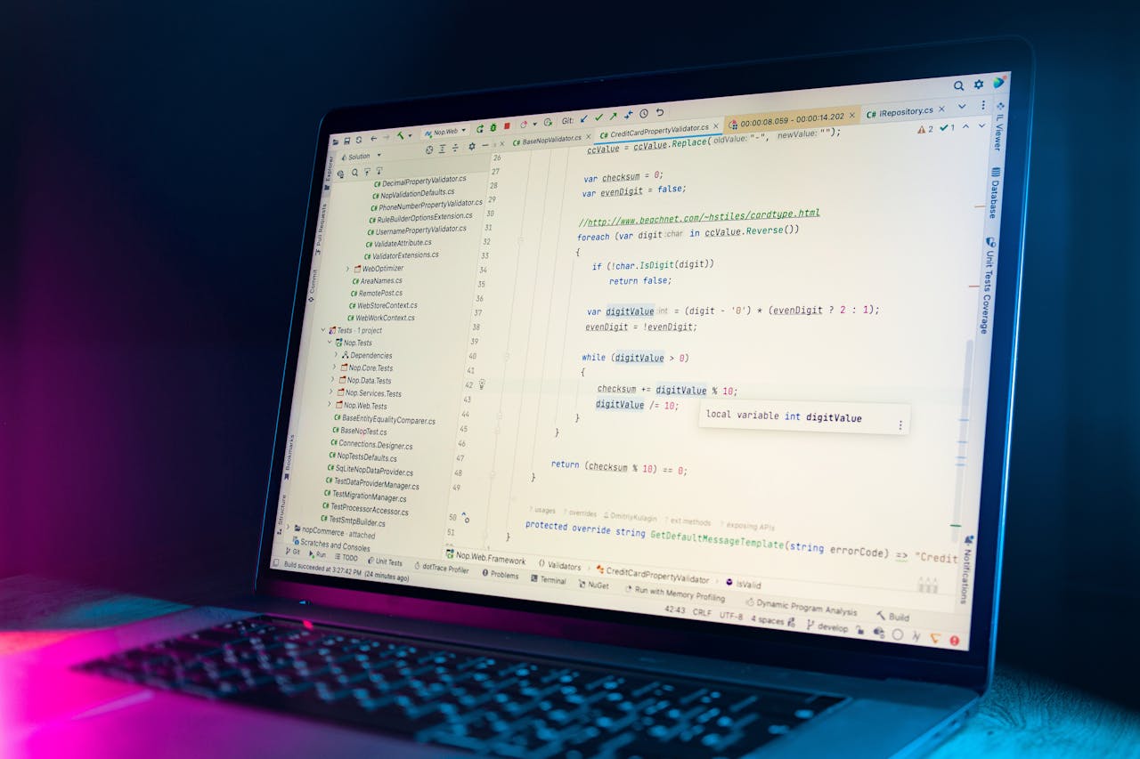 Services A laptop screen showing a code editor with visible programming code in a dimly lit environment.