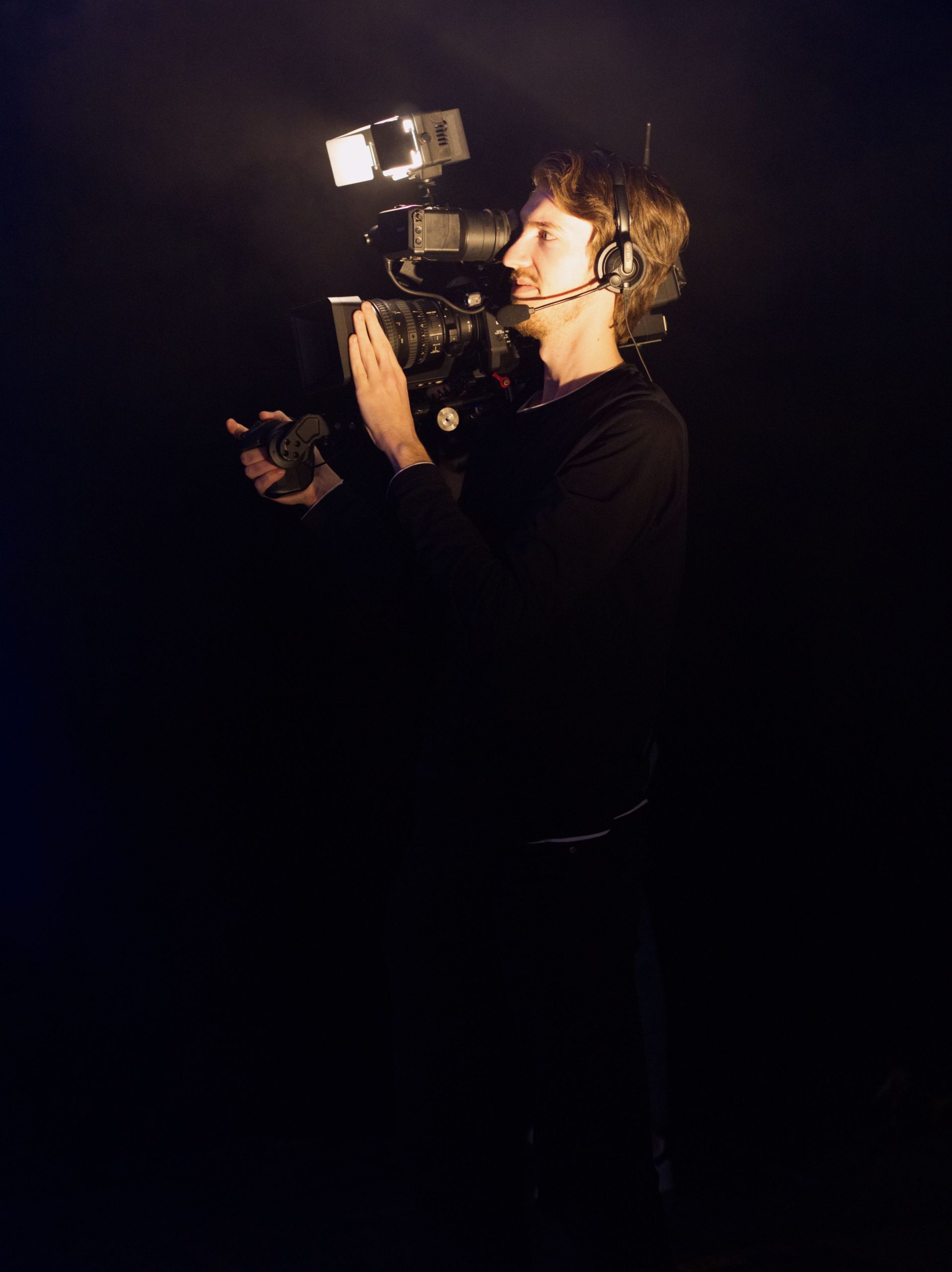 Camarógrafo operando cámara profesional en estudio de televisión